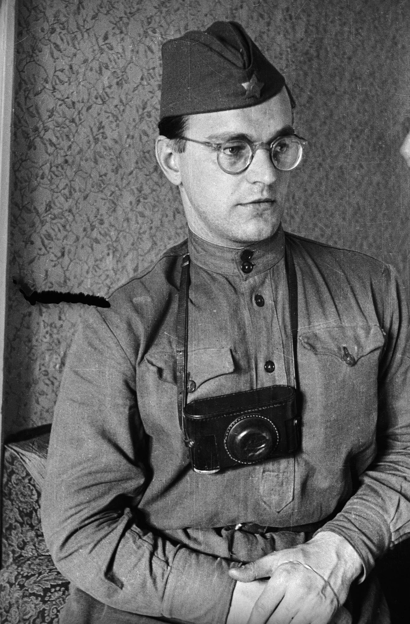 Eine Aufnahme von Valery Faminsky in sowjetischer Uniform. Er hat sich seine Kamera am Gurt um den Hals gehängt